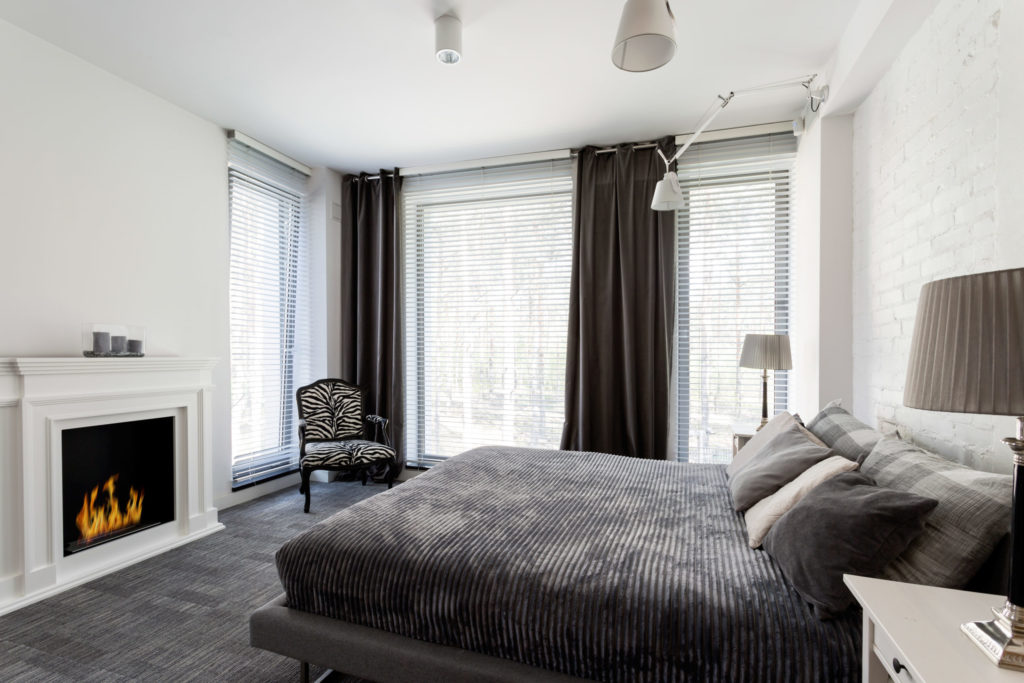 Grey bedroom with fireplace and bed